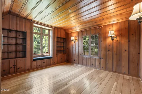 a view of a room with wooden walls and a window