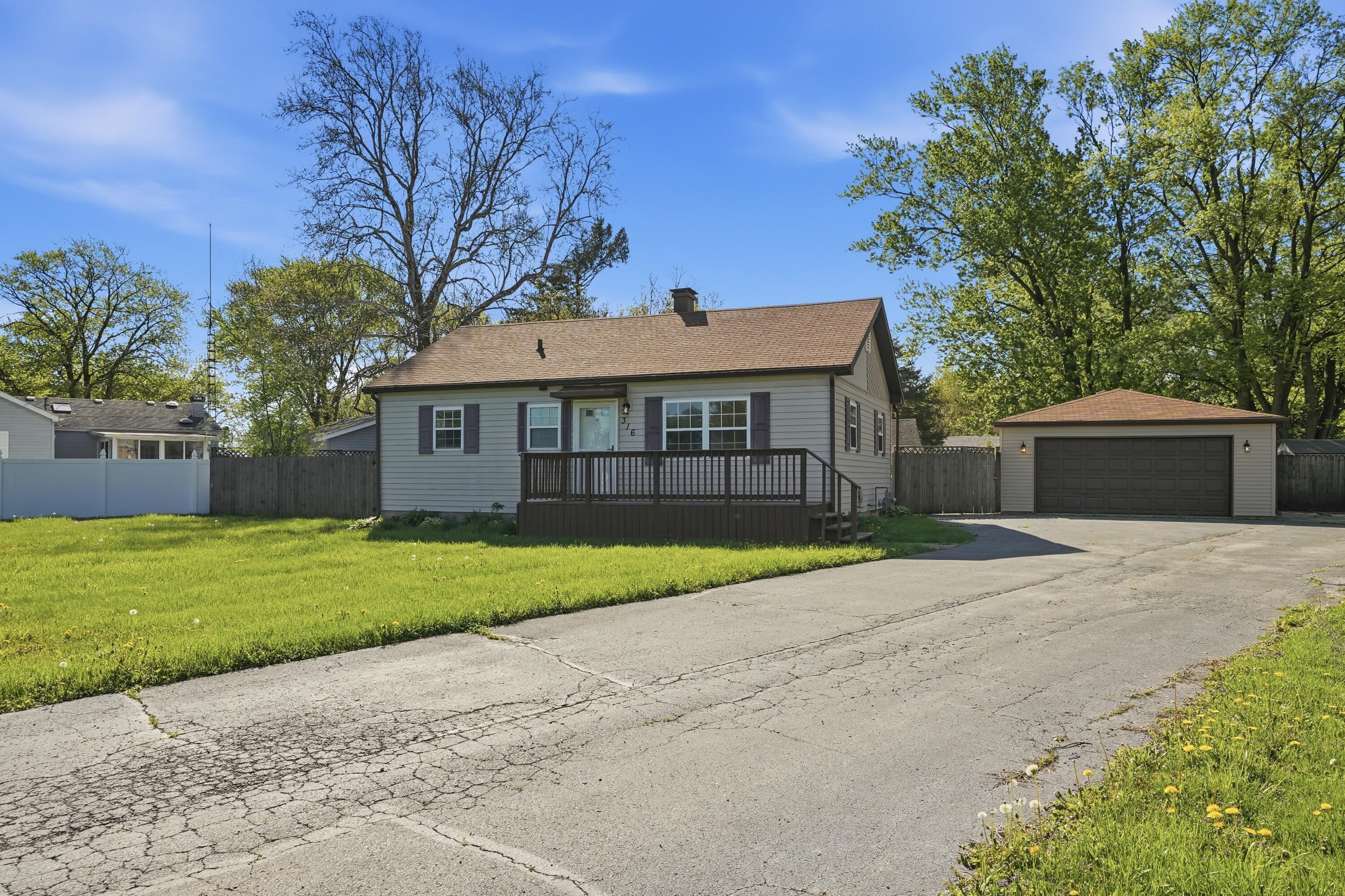 316 Oak Circle Crown Point, IN 46307 - Photo 14 of 19 a front view of a house with a garden and trees