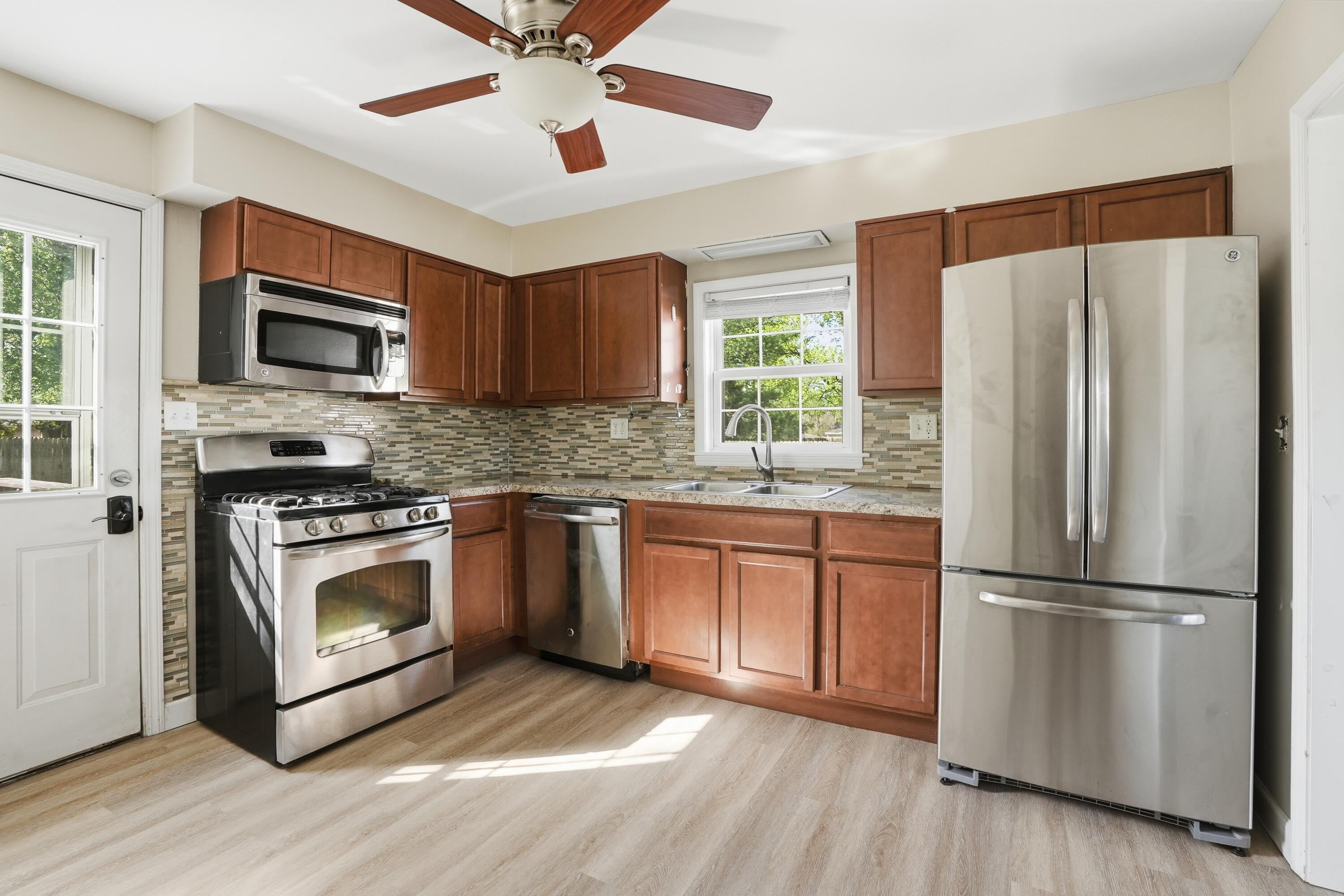 316 Oak Circle Crown Point, IN 46307 - Photo 2 of 19 a kitchen with granite countertop stainless steel appliances a refrigerator cabinets and a window