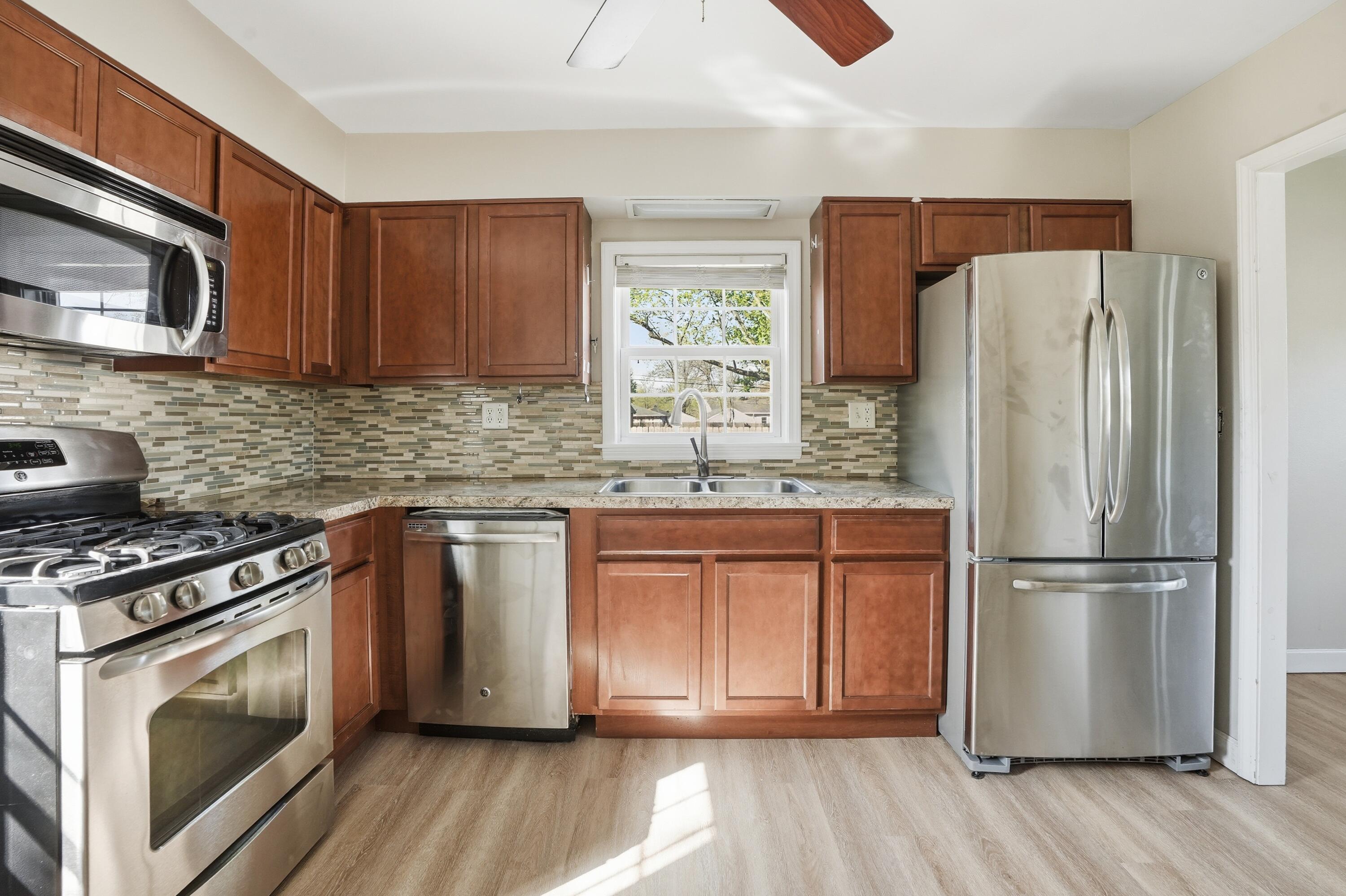 316 Oak Circle Crown Point, IN 46307 - Photo 4 of 19 a kitchen with granite countertop wooden floors stainless steel appliances and sink