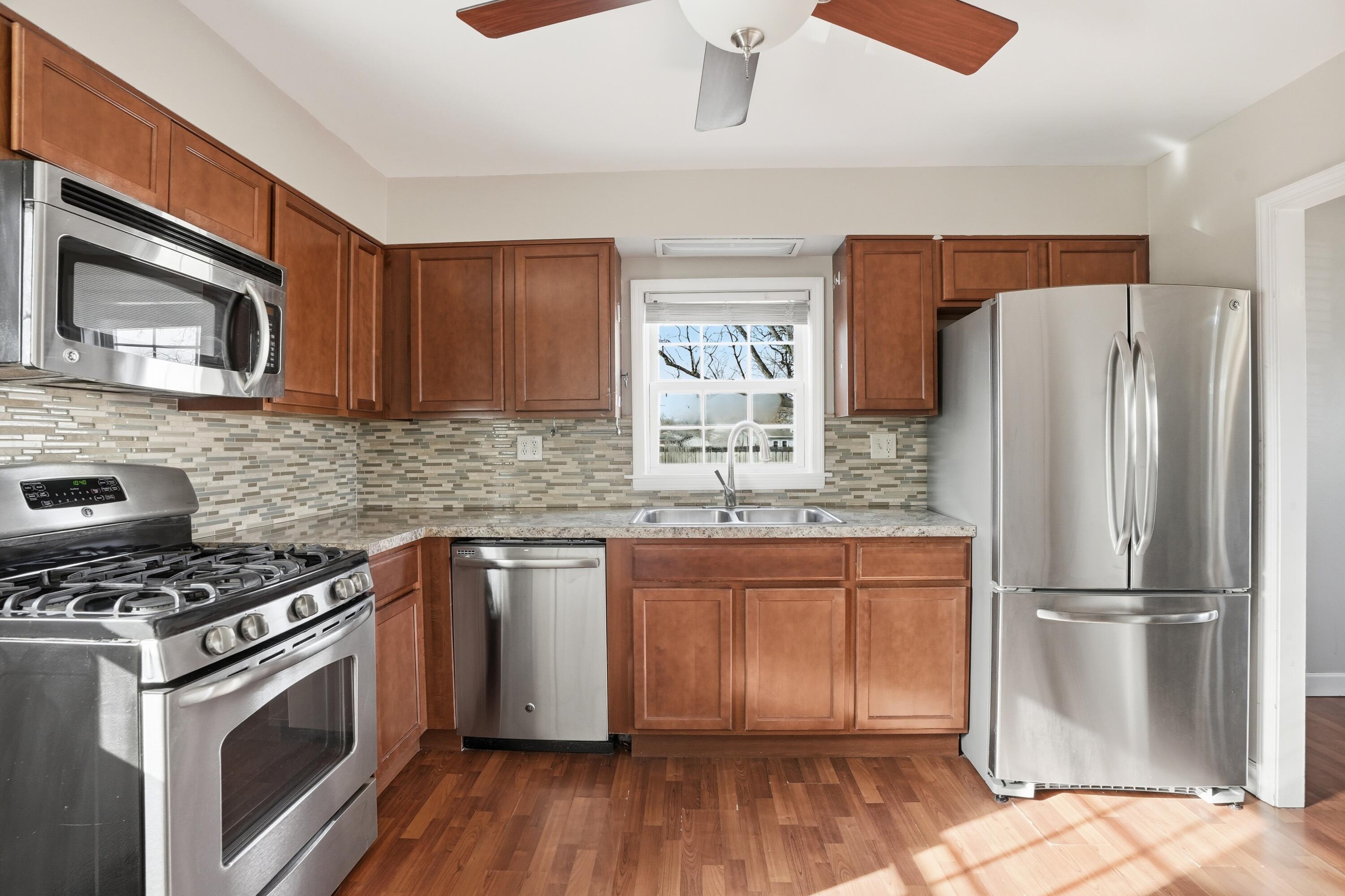 316 Oak Circle Crown Point, IN 46307 - Photo 9 of 19 a kitchen with granite countertop wooden cabinets a refrigerator and a stove top oven