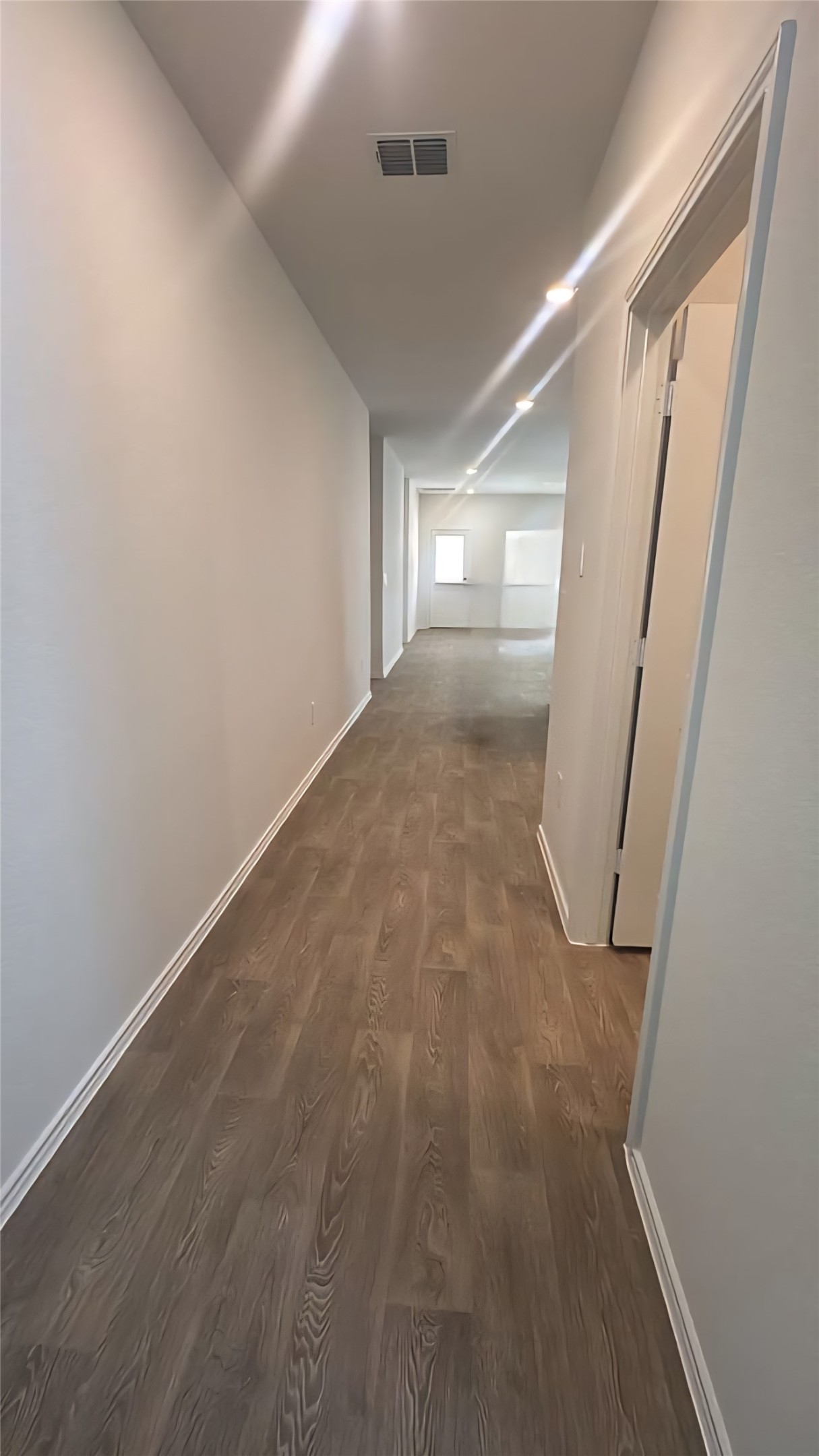 174 Balmorhea Street Kyle, TX 78640 - Photo 12 of 29 A lengthy hallway boasts abundant recessed lighting and durable wood flooring.
