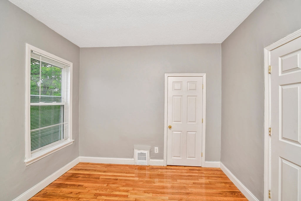 352 Norfolk Street, Unit 3 Boston, MA 02124 - Photo 9 of 12 a view of an empty room with wooden floor and a window