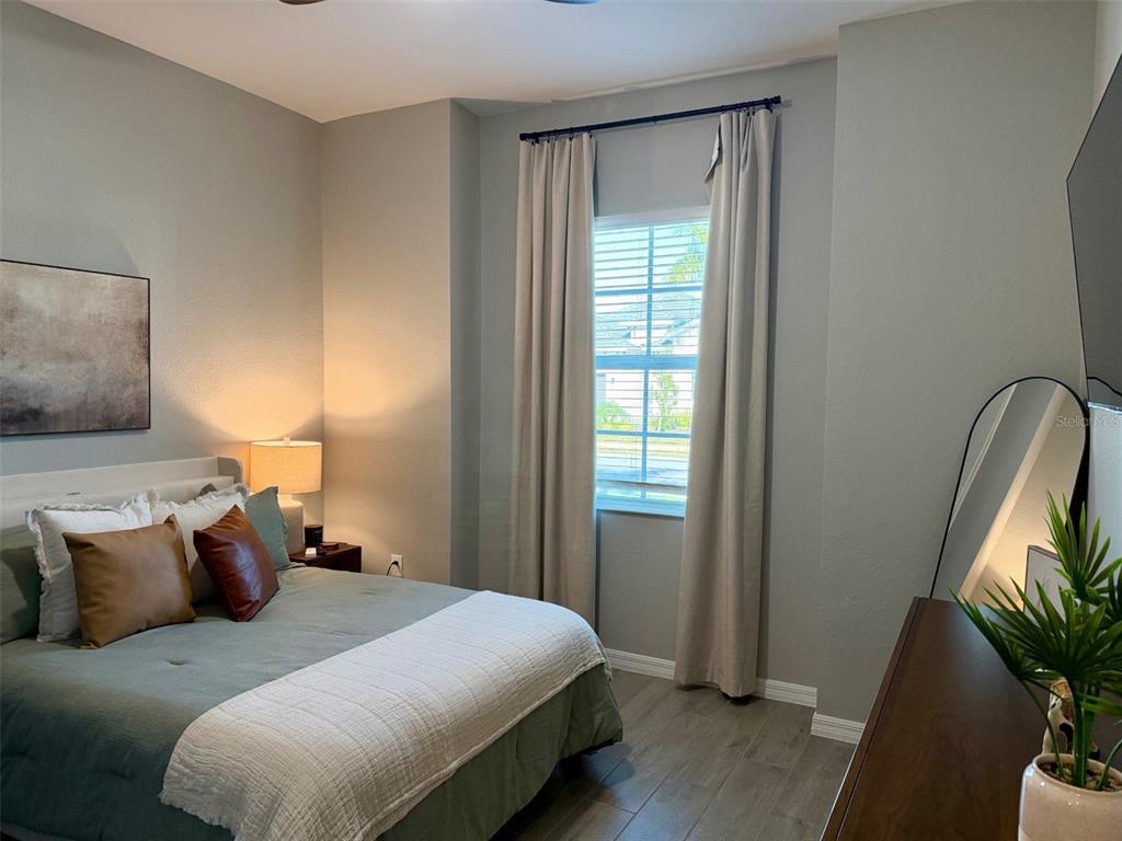 17577 Santorini Court Venice, FL 34293 - Photo 14 of 54 a bedroom with a bed and a potted plant