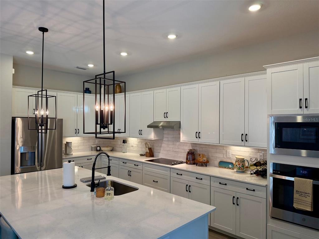 17577 Santorini Court Venice, FL 34293 - Photo 4 of 54 a kitchen with stainless steel appliances granite countertop a sink a stove and refrigerator