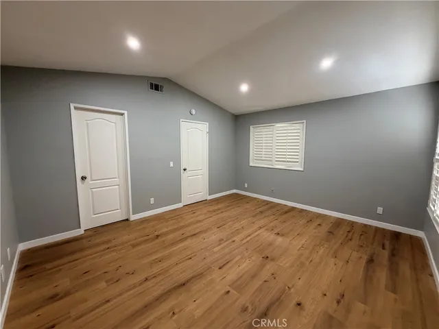 a view of empty room with window and wooden floor