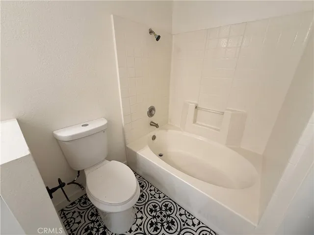 a white toilet sitting next to a bath tub