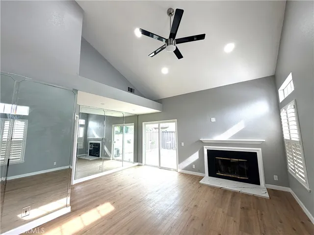 a view of empty room with wooden floor and fireplace