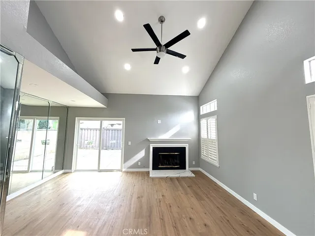 a view of empty room with wooden floor and fireplace