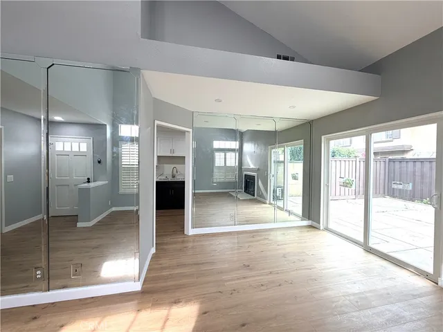 a view of a hallway with wooden floor fireplace and living room