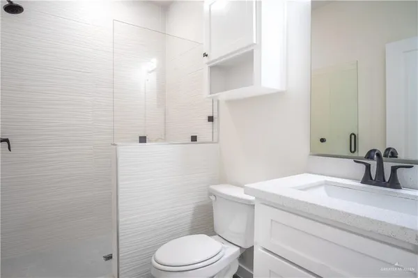 a bathroom with a toilet a sink and mirror