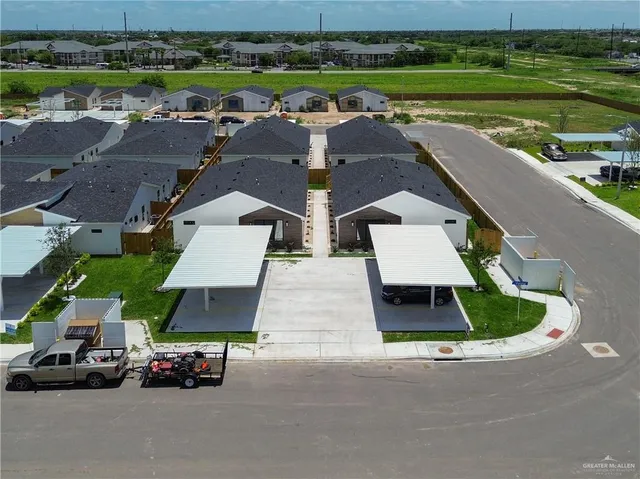 an aerial view of a house with a garden and lake view