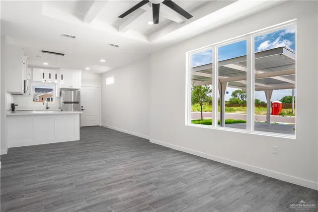 a view of a kitchen with wooden floor and windows