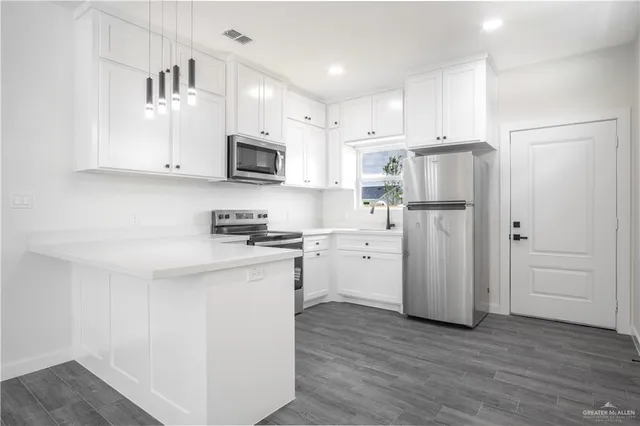 a kitchen with white cabinets and stainless steel appliances