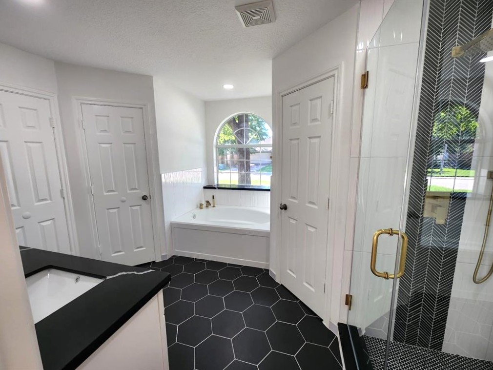 206 Doncaster Conroe, TX 77303 - Photo 14 of 28 a bathroom with a bathtub and a shower