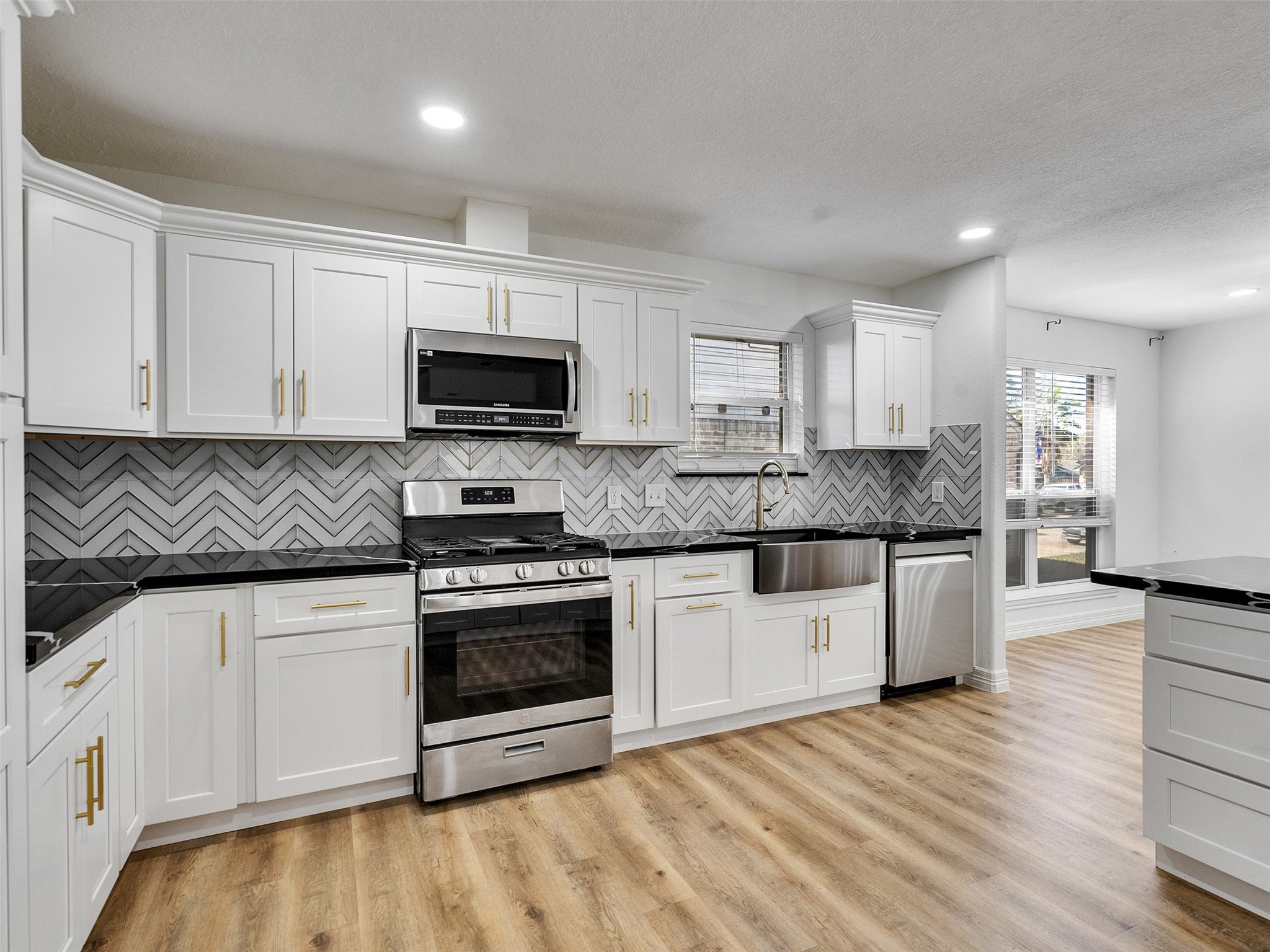 206 Doncaster Conroe, TX 77303 - Photo 21 of 38 a kitchen with granite countertop a stove top oven a sink and white cabinets