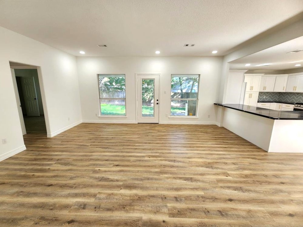 206 Doncaster Conroe, TX 77303 - Photo 3 of 28 a view of an empty room with window and wooden floor