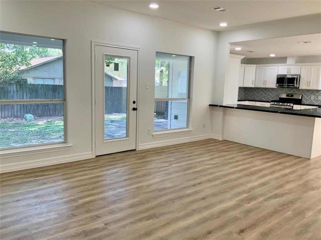 206 Doncaster Conroe, TX 77303 - Photo 4 of 28 a view of a kitchen with wooden floor and a window