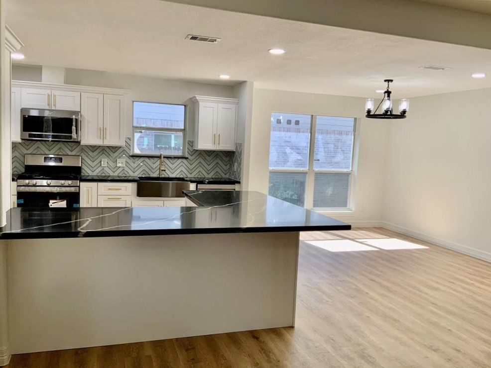 206 Doncaster Conroe, TX 77303 - Photo 6 of 28 a kitchen with stainless steel appliances granite countertop a stove a sink and a microwave