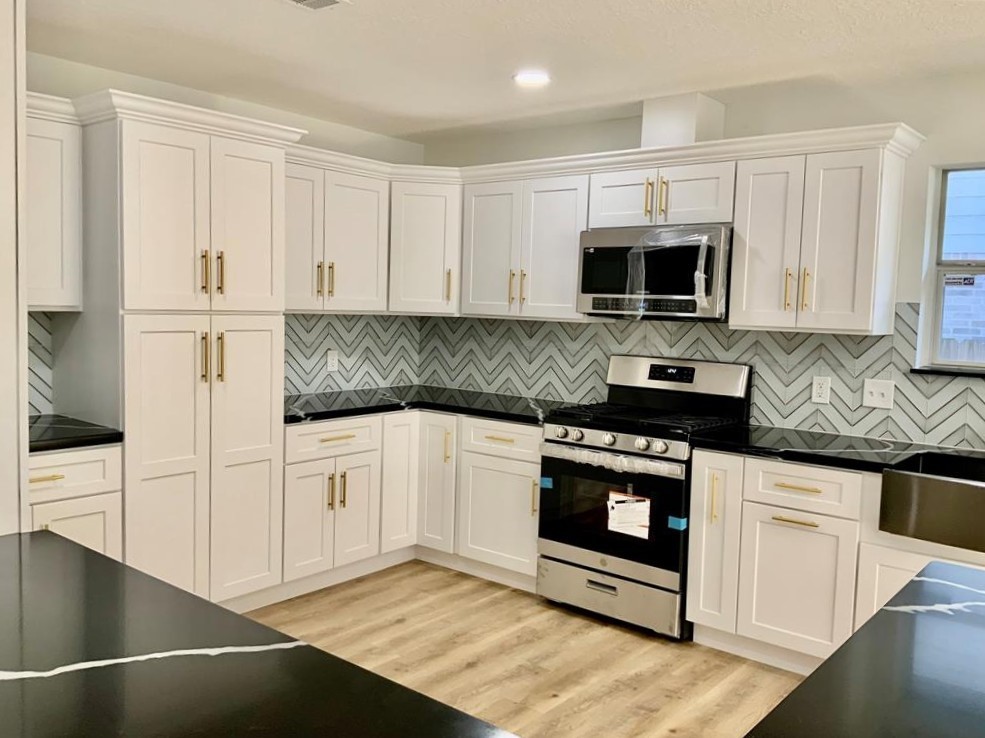 206 Doncaster Conroe, TX 77303 - Photo 8 of 28 a kitchen with stainless steel appliances granite countertop a stove a sink and white cabinets