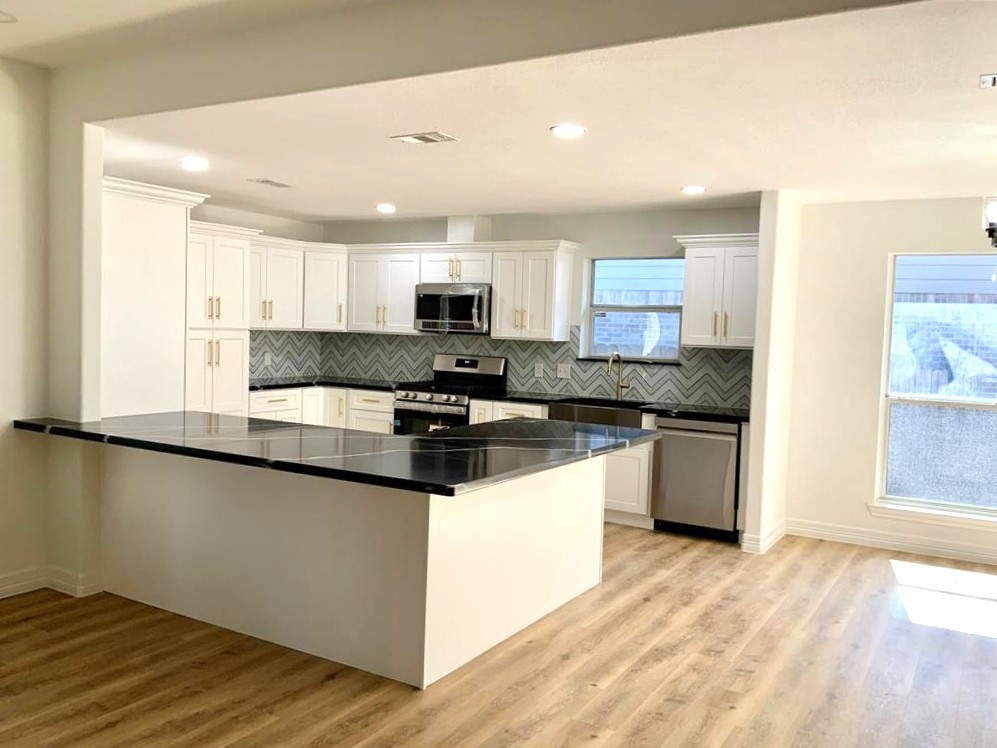 206 Doncaster Conroe, TX 77303 - Photo 9 of 28 a kitchen with kitchen island granite countertop a sink cabinets and wooden floor