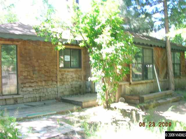 17900 South Virginia Street Reno, NV 89521 - Photo 1 of 9 a backyard of a house with large trees and wooden fence