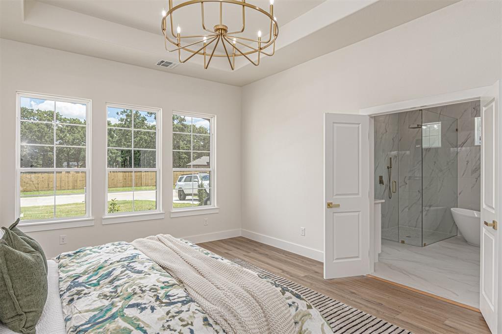 360 Dalton Road Canton, TX 75103 - Photo 15 of 33 Spacious bedroom featuring wood-finish flooring and a contemporary chandelier