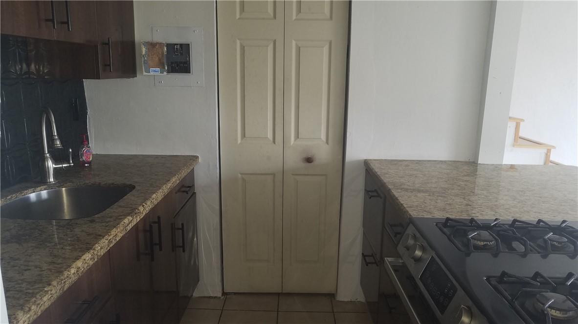 1300 West 53rd Street, Unit 7 Hialeah, FL 33012 - Photo 5 of 22 a kitchen with a granite countertop sink a refrigerator and washer