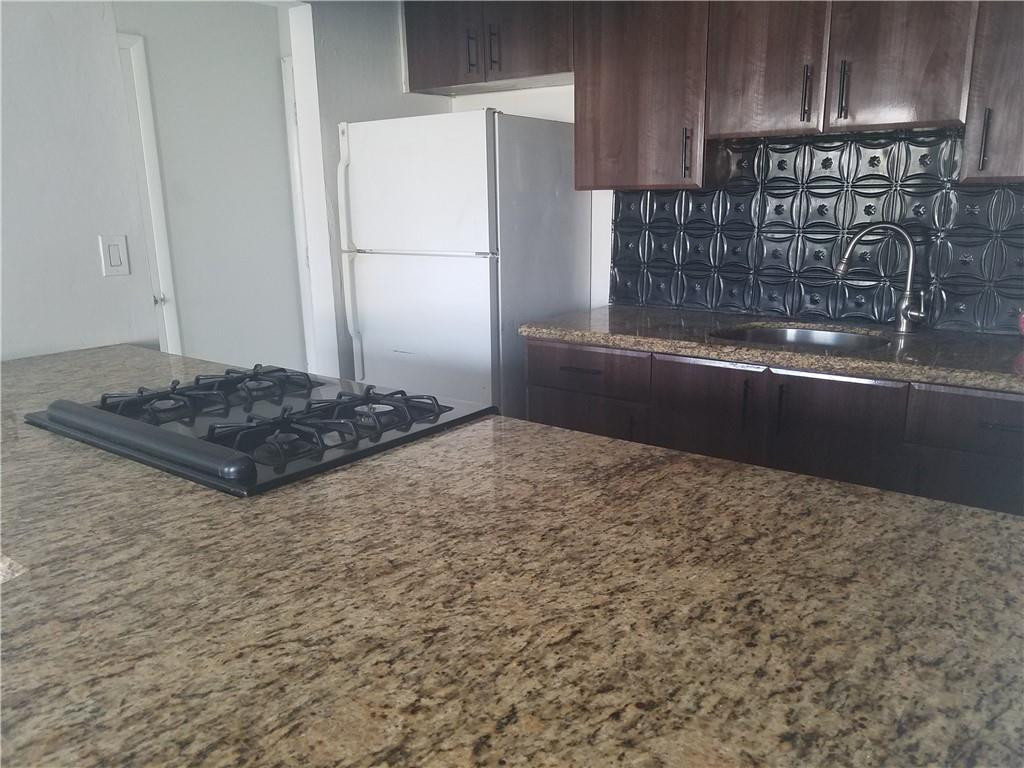 1300 West 53rd Street, Unit 7 Hialeah, FL 33012 - Photo 7 of 22 a kitchen with kitchen island sink and stove