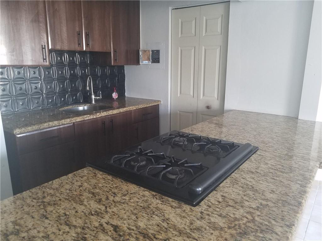 1300 West 53rd Street, Unit 7 Hialeah, FL 33012 - Photo 8 of 22 a kitchen with a stove and a cabinets