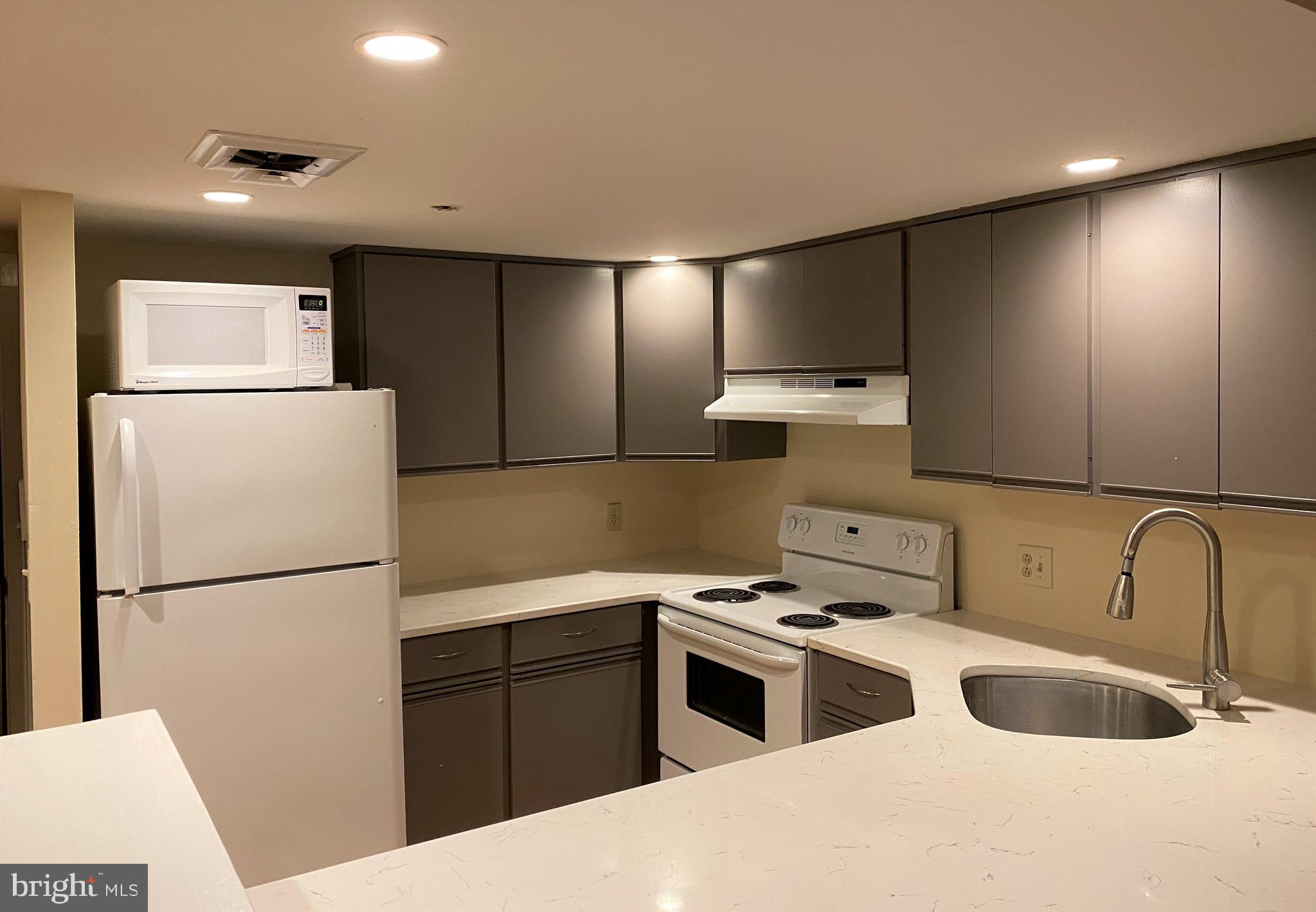 21 North 3rd Street, Unit 4C Philadelphia, PA 19106 - Photo 7 of 14 a kitchen with a refrigerator sink and white cabinets