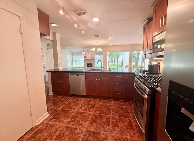 a kitchen with stainless steel appliances granite countertop a refrigerator and a sink