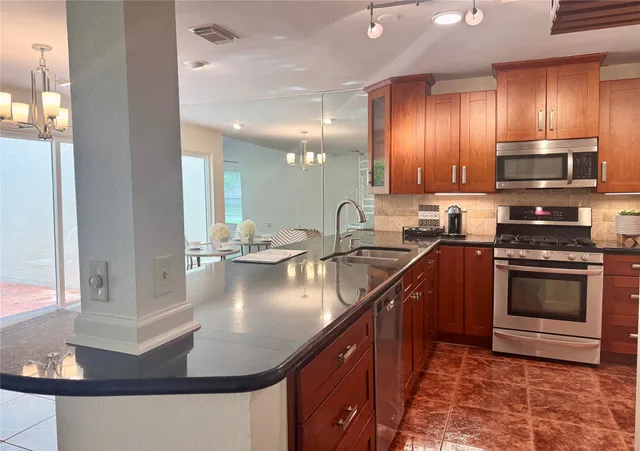 a kitchen with stainless steel appliances granite countertop a sink stove and cabinets