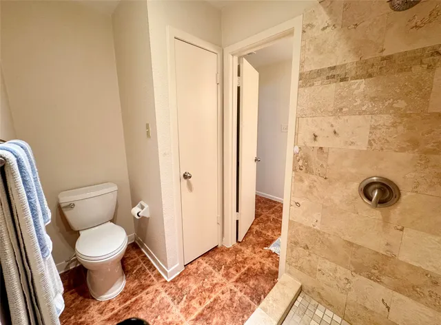 a bathroom with a toilet and a shower