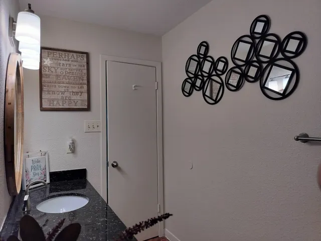 a bathroom with a granite countertop sink and a mirror