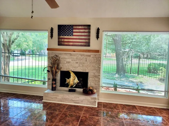 a living room with a fireplace and a floor to ceiling window