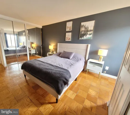 a bedroom with a bed and wooden floor