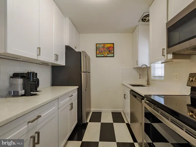 a kitchen with a sink a refrigerator and cabinets