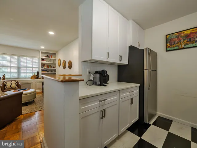 a kitchen with stainless steel appliances granite countertop a refrigerator sink and white cabinets