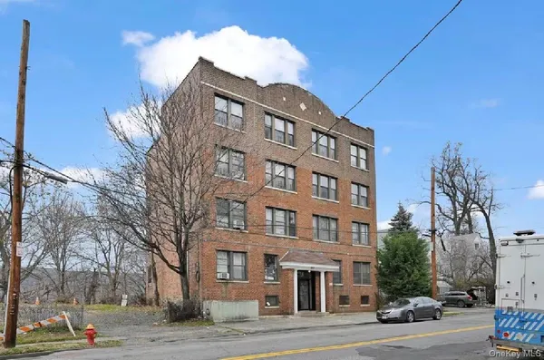 a front view of a building with lot of trees