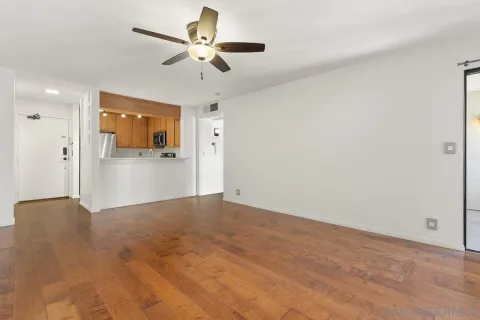a view of a livingroom with a ceiling fan wooden floor and a ceiling fan