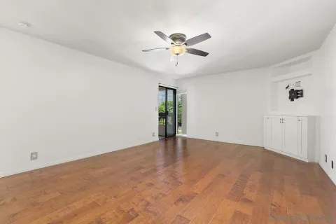 a view of an empty room with chandelier fan