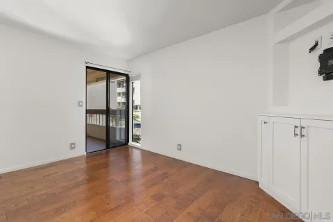 a living room with furniture a rug potted plant and a window