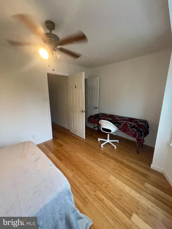 a view of a room with wooden floor and a ceiling fan