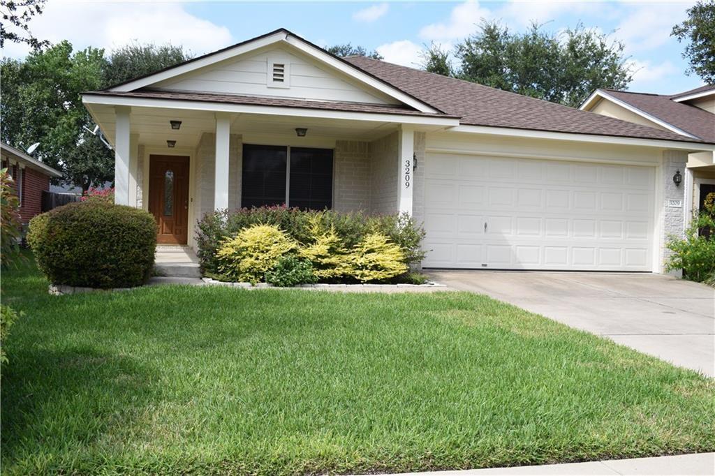 Front exterior featuring a covered entry, wood-finish front door with an inset window, two exterior light fixtures, a two-car garage, and a concrete driveway