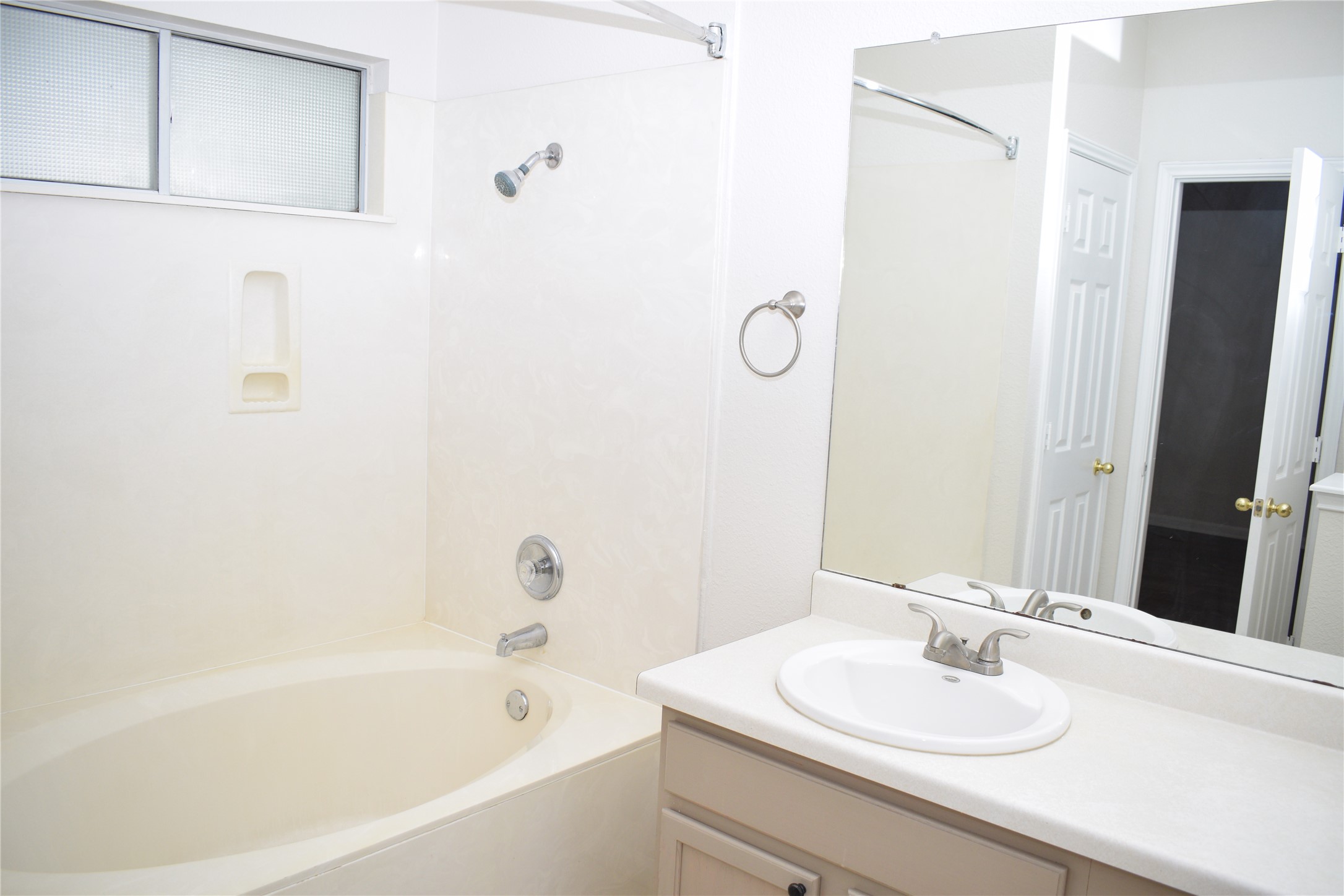 3209 Port Anne Way Leander, TX 78641 - Photo 14 of 30 Bathroom featuring an integrated bathtub and shower combination, a frosted glass window, a vanity with an integrated sink, and a large wall-mounted mirror
