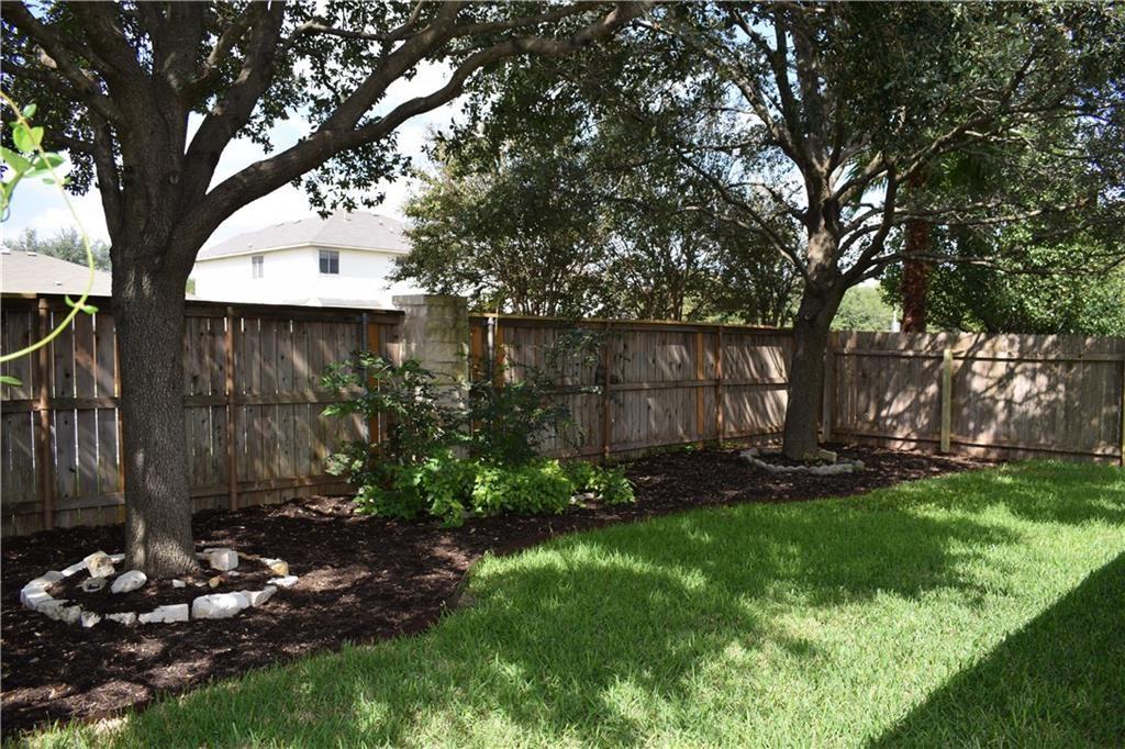3209 Port Anne Way Leander, TX 78641 - Photo 19 of 30 Expansive backyard featuring a manicured lawn and mature trees