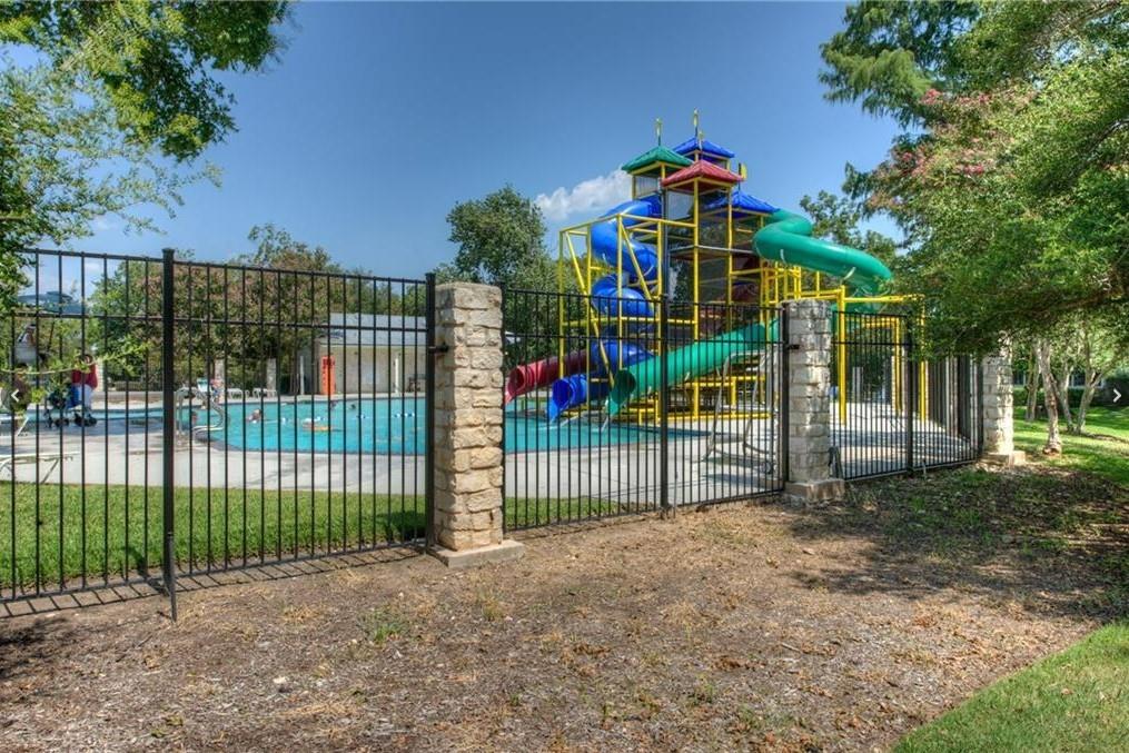 3209 Port Anne Way Leander, TX 78641 - Photo 27 of 30 Recreational aquatic area featuring a multi-level play structure with slides, a splash pad, and a perimeter fence with stone pillars