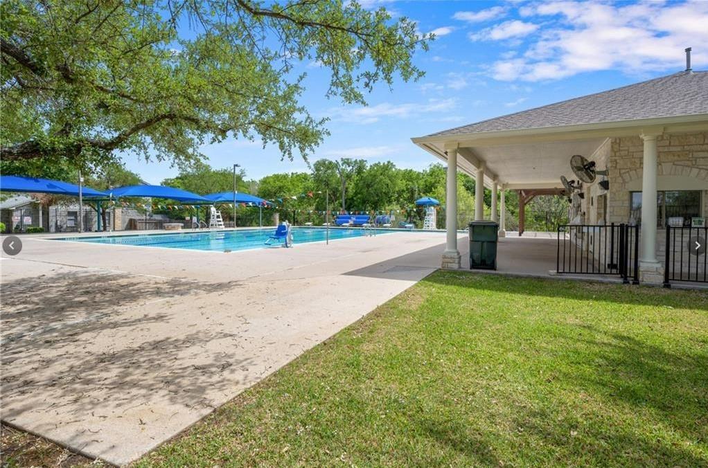 3209 Port Anne Way Leander, TX 78641 - Photo 28 of 30 Recreational swimming pool with an expansive concrete deck, shaded by blue canopies and mature trees