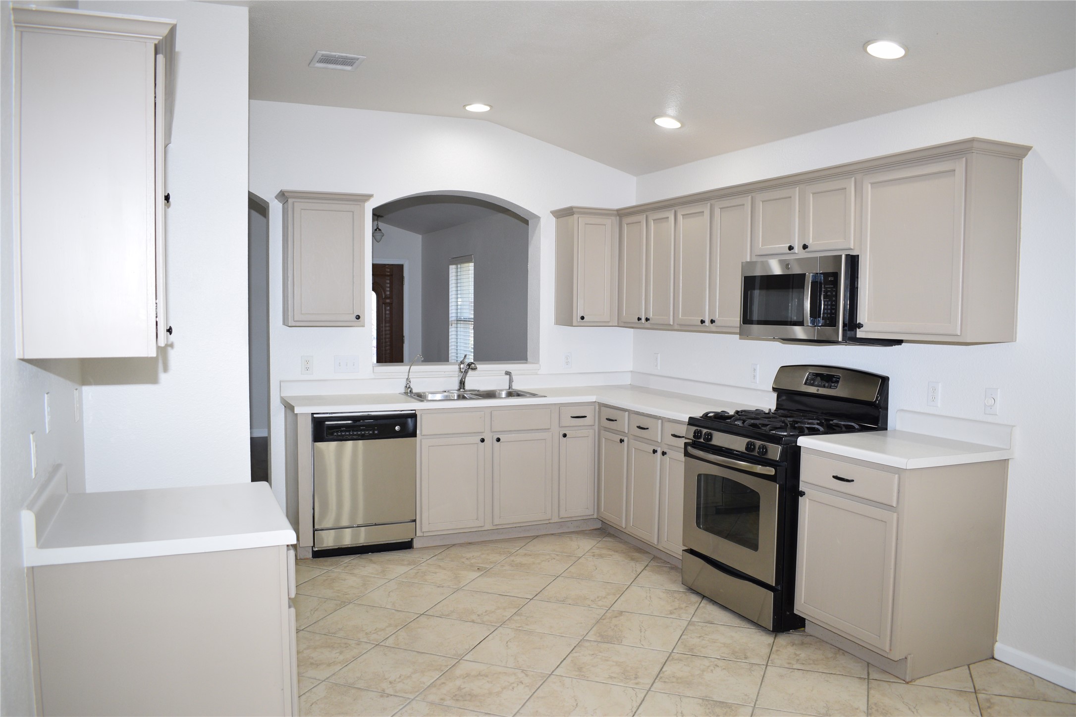 3209 Port Anne Way Leander, TX 78641 - Photo 3 of 30 Spacious kitchen featuring neutral-toned cabinetry, white countertops, stainless steel appliances, and a tile floor